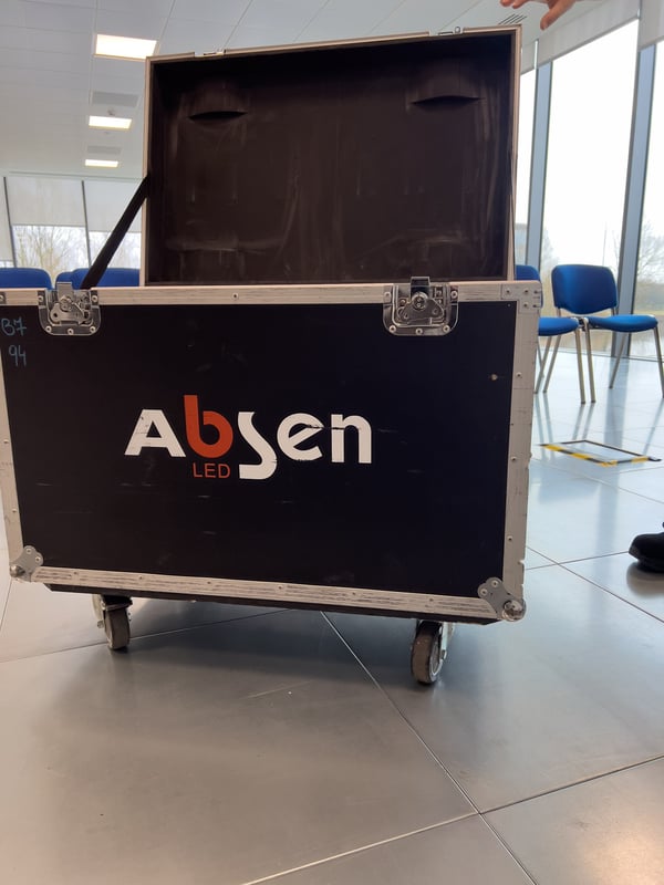 Equipment case on wheels for Absen LED panels in a conference room setting.