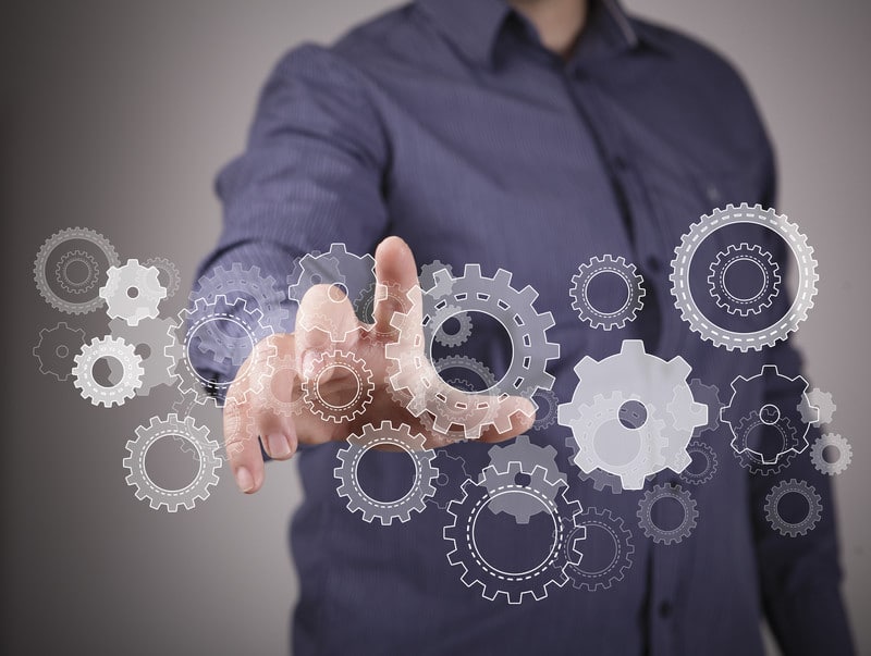 Hand interacting with virtual gears, symbolizing innovation in event production technology and AV services.