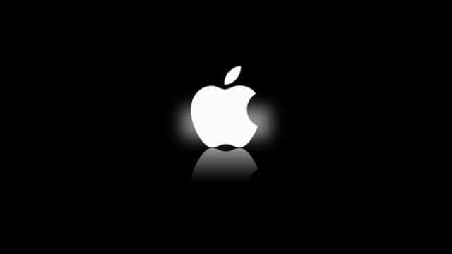 The image displays a white apple logo on a black background with subtle reflection beneath.