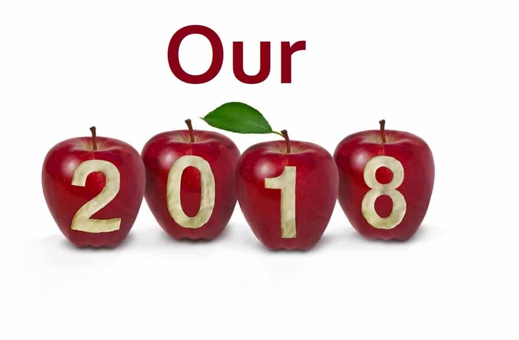 Four apples display the year 2018, with carved numbers, under the word Our, symbolizing a fresh start or annual theme.