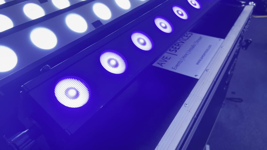 LED stage lighting equipment with purple and white beams used for event production by AVE Services.