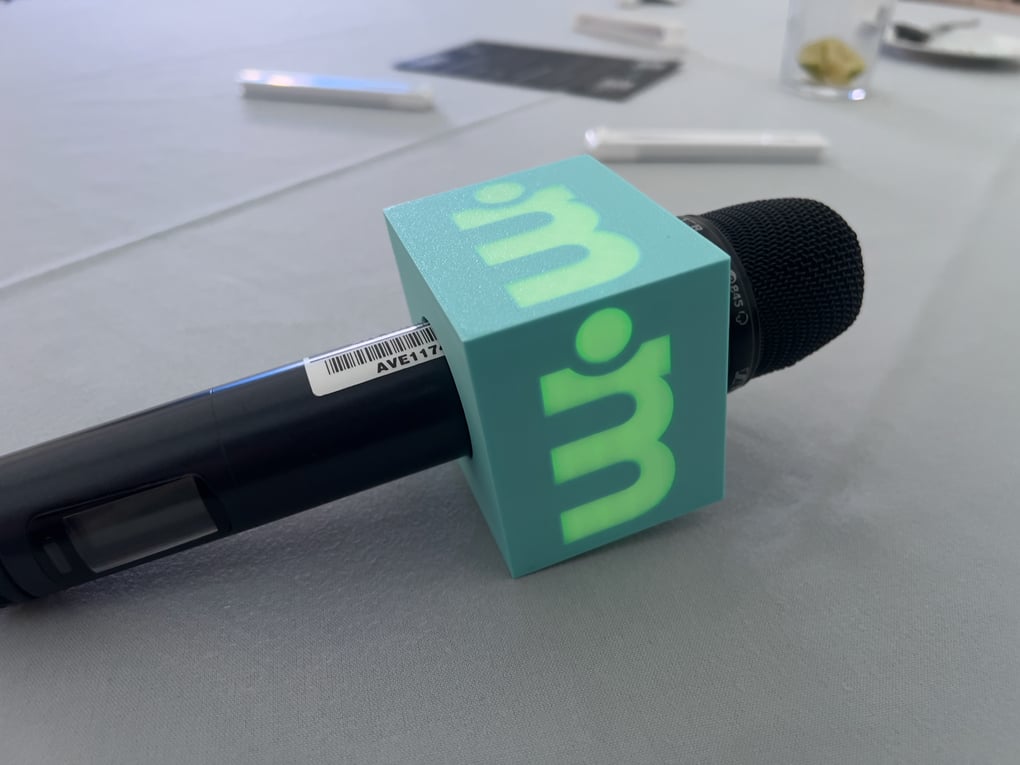 Wireless microphone with branded mic flag on a conference table, ready for event use.