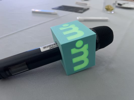 Wireless microphone with branded mic flag on a conference table, ready for event use.