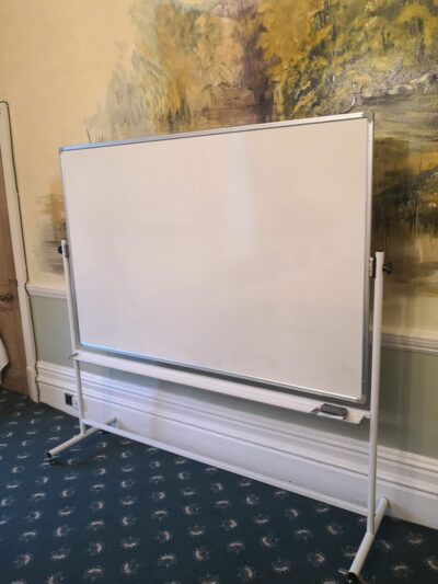Freestanding whiteboard set up for conference use in an elegantly decorated room with a mural and carpeted floor.