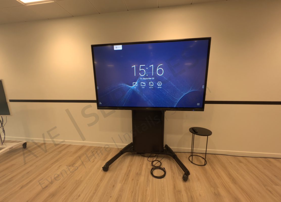 Large digital display setup on a stand in a corporate conference room, with sleek wooden flooring and modern decor.
