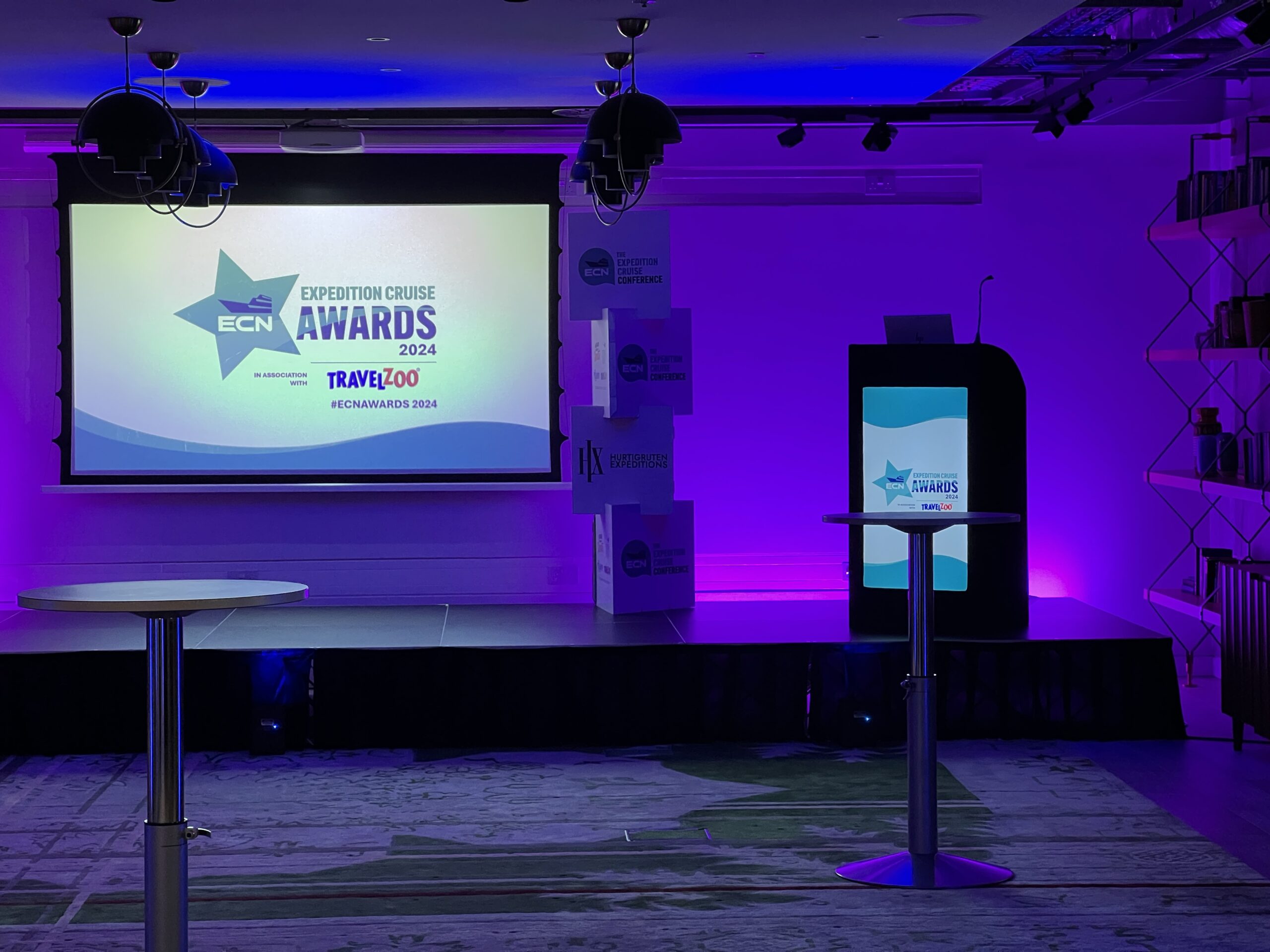 Stage setup for ECN Expedition Cruise Awards with podium, projector screen, and event lighting.