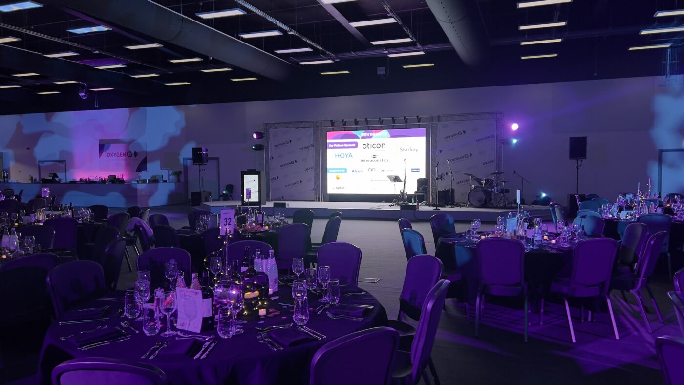 Conference, large conference, AV, Audio visual, LED video wall, large screens, PA system, Microphones, lighting, awards, live streaming, projection, annual event, technicians, AVE Services Across the venue, our team installed and managed a wide range of AVl equipment, including: LED Video Wall – A large, high-resolution display perfect for dynamic visuals and branding in the main conference space with banner. RCF Speakers Large Screens – Additional displays placed around the venue to ensure visibility for all attendees, even in breakout areas. G3 Wireless Microphones Projection Equipment – Used in smaller rooms to display presentations and videos. Lighting Live Streaming Equipment – Full setup streaming, allowing remote audiences to engage with every session. On-Site Technicians – Our experienced team remained on-site to ensure everything ran smoothly from start to finish.