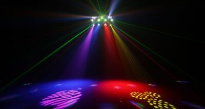 Dynamic stage lighting with colorful beams and patterned spotlights at an event venue.