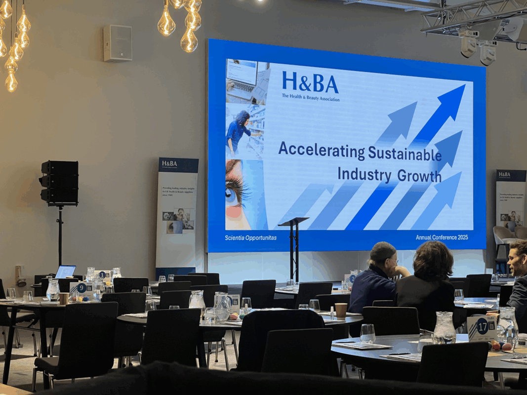 Conference room setup with large screen displaying Accelerating Sustainable Industry Growth for H&BA Annual Conference 2025.
